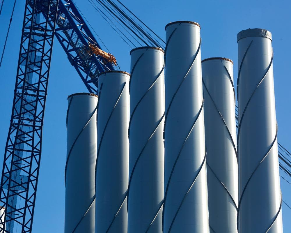 Wind turbine blades stand beside a crane at the Hull Siemens blade factory