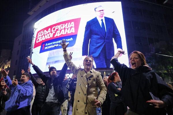 People cheering after the polls closed in Belgrade, Serbia, on Sunday. Above them was a campaign ad for Aleksandar Vucic, the defeated leader.